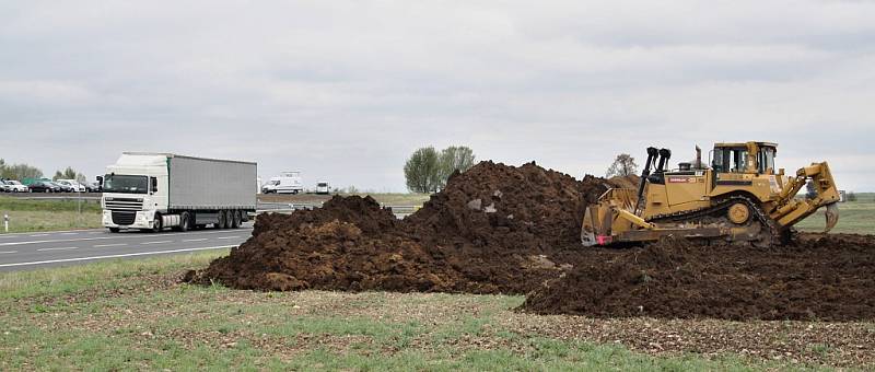 Zahájení stavby dálnice D7 v úseku od Bitozevsi do Postoloprt. Buldozer skrývá ornici v místě budoucí mimoúrovňové křižovatky u Postoloprt.