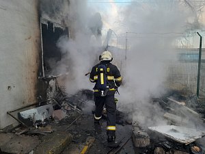 Hasiči bojují s požárem v Postoloprtské ulici v Lounech.