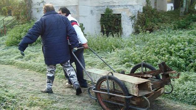 Muži vezou železo zpět do kontejneru. 