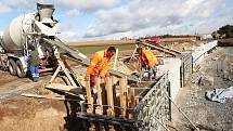 Dělníci staví opěrné zdi na silnici u Staňkovic