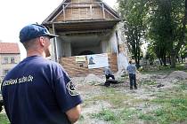 Odsouzení muži pracují u lenešického kostela. Při práci je hlídá vězeňská služba.