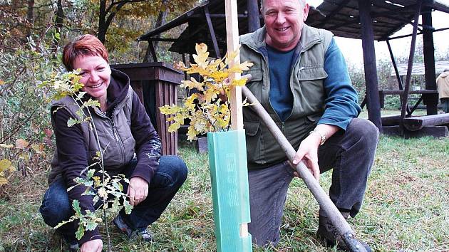 Přemysl Hautke s žateckou starostkou Zdeňkou Hamousovou dokončují sázení jednoho ze stromků, které dobrovolníci vysadili na naučné stezce v okolí Holedeče.