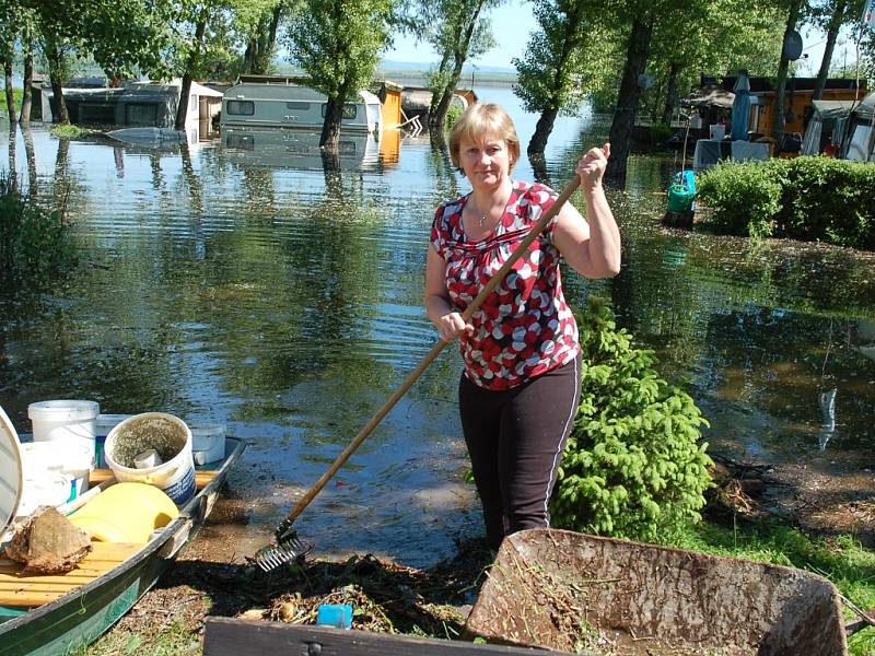 Vedoucí kempu U Hráze Lenka Jirkovská uklízí naplaveniny, které přinesla velká voda