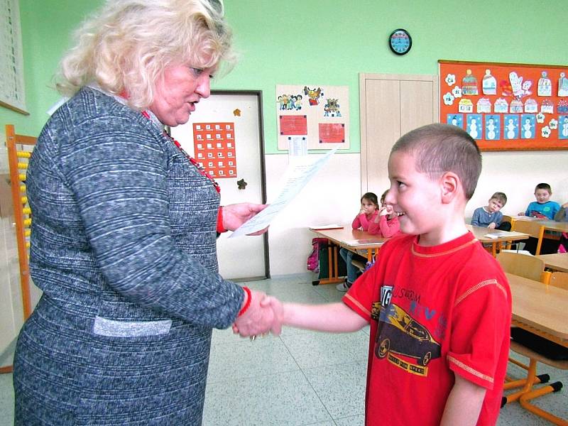 Dvojčata při přebírání prvního vysvědčení v žatecké škole. Na snímku učitelka Jana Piwková s Jeníkem.