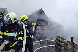 Hasiči bojují s požárem zahradního domku v Hořeticích.