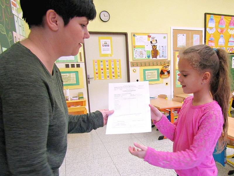 Dvojčata při přebírání prvního vysvědčení v žatecké škole.