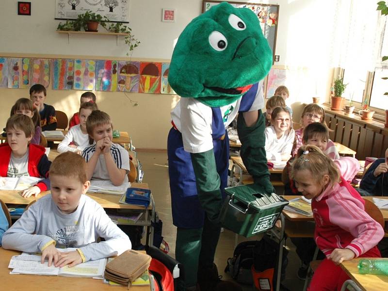 Žabák ukazuje dětem ze Základní školy Jižní v Žatci nádobu na sběr vybitých baterií. 