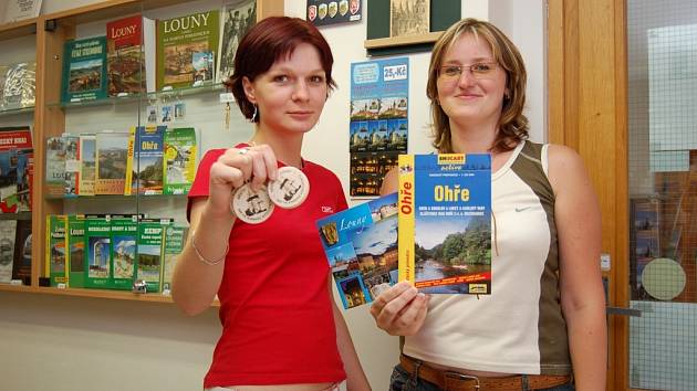 Mirka Hefnerová a Eva Jirásková  (zleva) z informačního centra v Lounech ukazují propagační předměty města. 