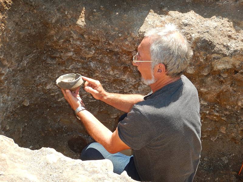 Vedoucí výzkumu Petr Holodňák vyzvedává nádobku z hrobu z doby stěhování národů.