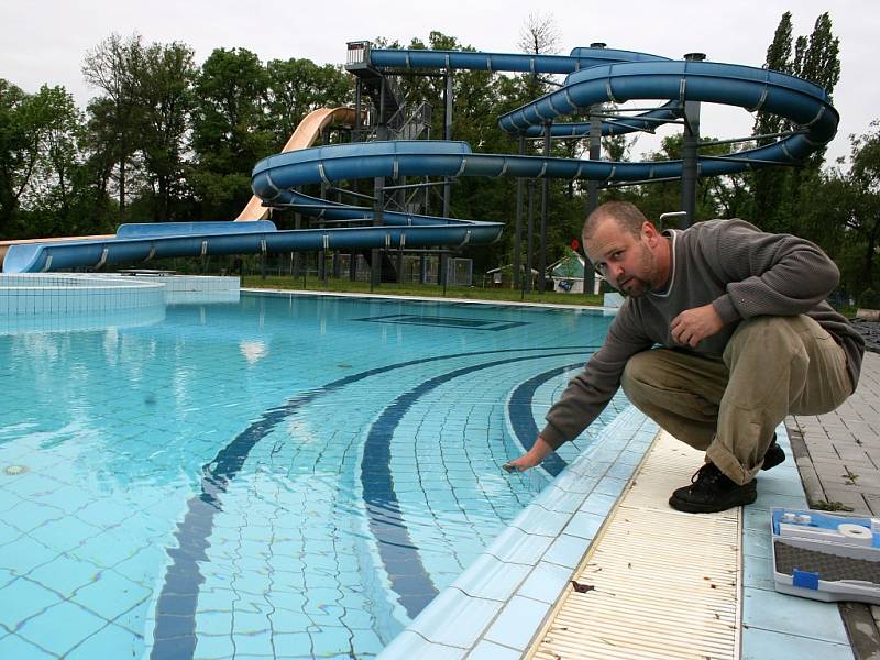 Radek Ulrych odebírá vzorek vody v napuštěném bazénu lounského koupaliště na hygienické rozbory. 