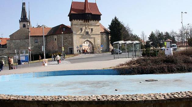 Kašna na Suzdalském náměstí v Lounech, v pozadí Žatecká brána