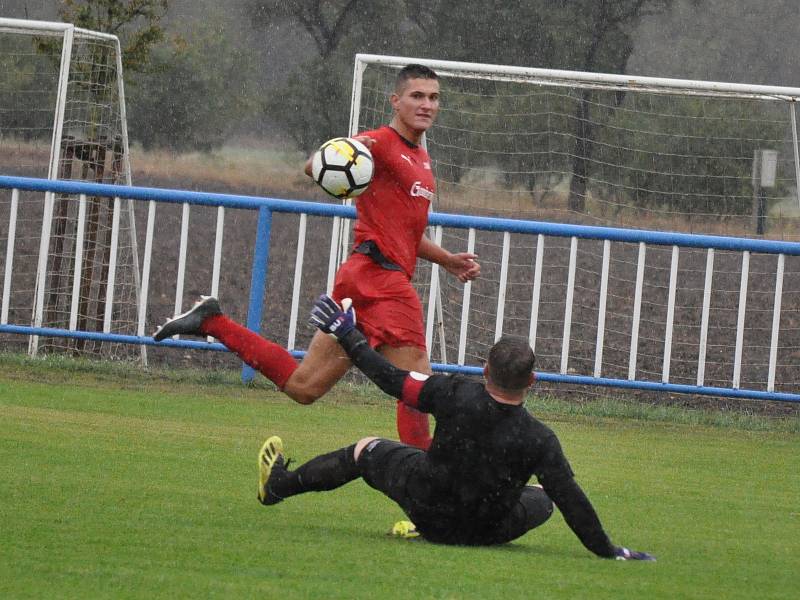 Za vytrvalého studeného deště nasázeli hráči Duchcova (v modrém) do sítě Lenešic sedm branek a mohli jet spokojeně domů.