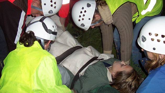 Dobrovolní záchranáři transportují pacienta s fixovanou nohou ve vakuové dlaze při cvičení u Perče.