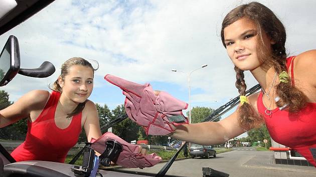 Studentky Gábina Šorfová a Veronika Žižková myjí přední okno automobilu na benzinové stanici v Žatci.