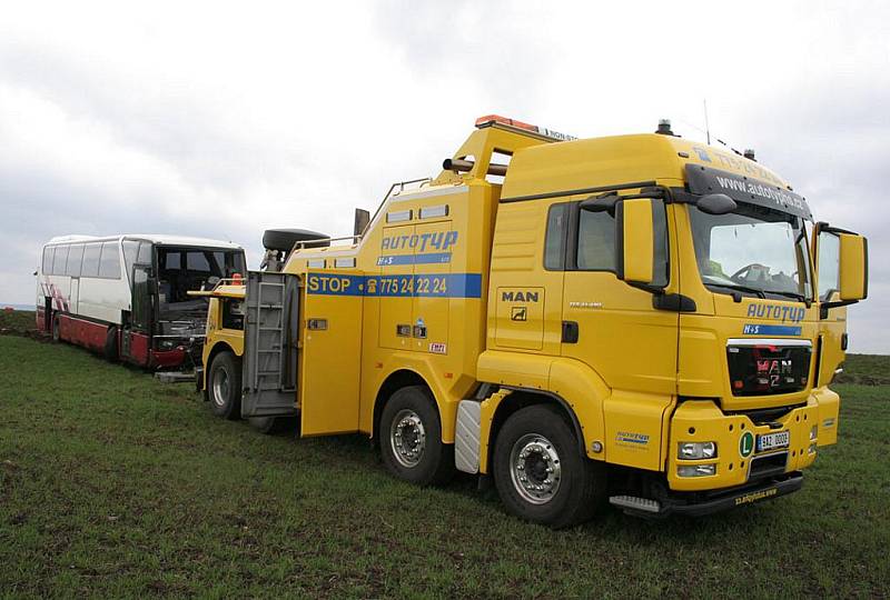 Poničený autobus odtahuje speciální technika