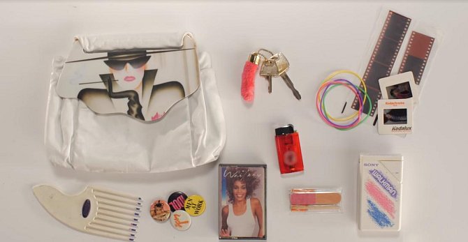 Obsah kabelky z roku 1986 - hřeben, placky na kabát, kazeta s oblíbenou hudbou, walkman, klíče, zapalovač, pilníček na nehty, gumičky do vlasů a případně i vyvolaný film k prohlížení na promítačce