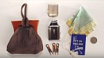 Obsah kabelky z roku 1936 - zrcátko, zapalovač s cigaretami, pinetky, kvalitní četba, látkový kapesník a mince na drožku