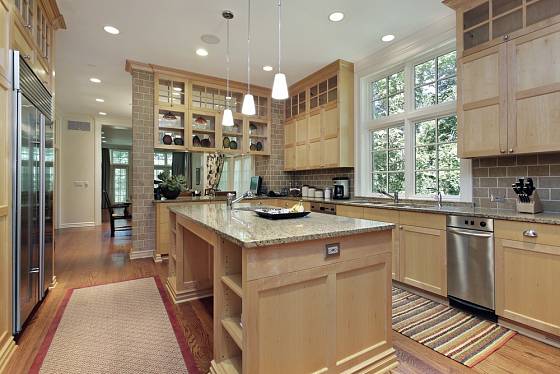 Prostorná kuchyně s dubovým dřevem a žulovou pracovní deskou.