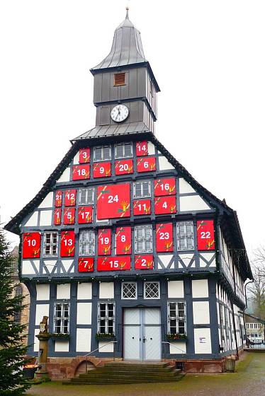 Historická radnice ve městě Uslar s okny vyzdobenými jako adventní kalendář.