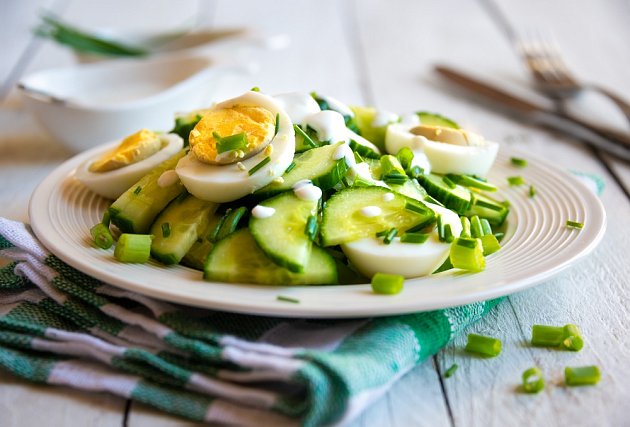 Salát s jarní cibulkou, vejce, okurkou a majonézou dodá pokrmu svěží chuť.