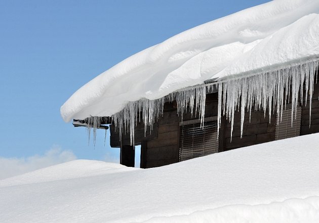 Sníh a rampouchy mohou vážně poškodit střechy.