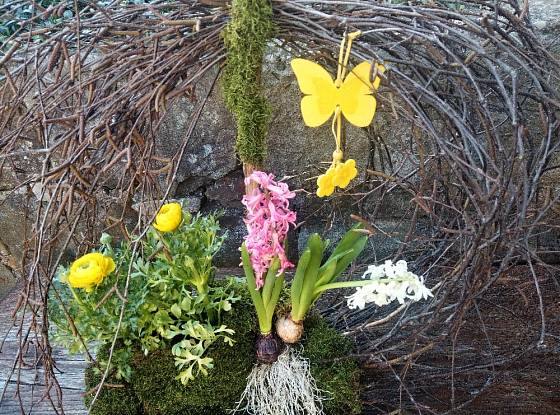 Jarní aranžmá s kvetoucími cibulovinami a motýlem.