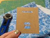 DIY výroba šikmého proužku: Do kousku kartonu prostřihnete několik otvorů.