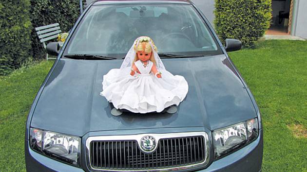svatební panenka na kapotě auta