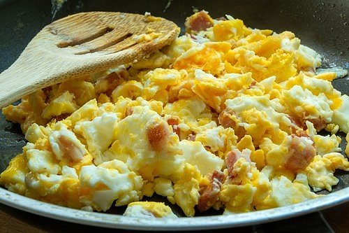 Ve chvíli, kdy vajíčka začínají tuhnout, přidejte jednu čajovou lžičku majonézy a stále pomalu míchejte.