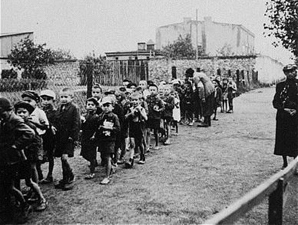 Děti z lodžského ghetta směřují do transportu do vyhlazovacího tábora.