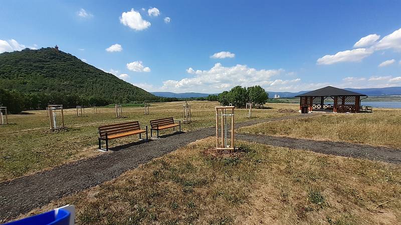 Dokončovaný altán v městském ovocném sadu s výhledem na jezero Most, kostel a hrad Hněvín.