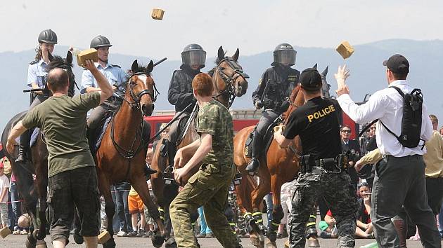 Ukázka zásahu policistů na koních proti demonstrantům. Vzduchem létal molitan.