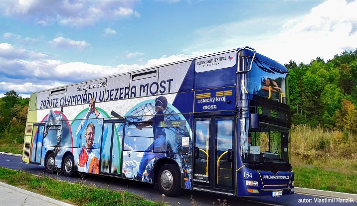 Dvoupatrový autobus s olympijskou grafikou.