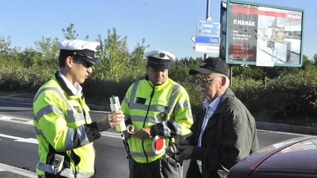 Policejní hlídka jednomu z řidičů ukazuje, že je vše v pořádku.