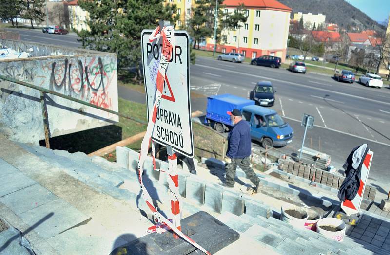 Řemeslníci opravují schody mezi parkem pod nemocnicí a ulicí Slovenského národního povstání v Mostě.