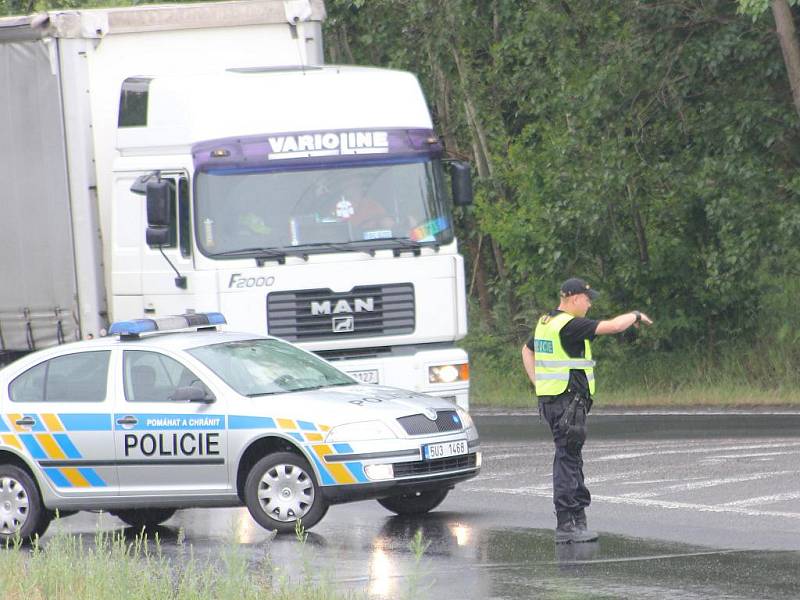 Policista usměrňuje na křižovatce dopravu.