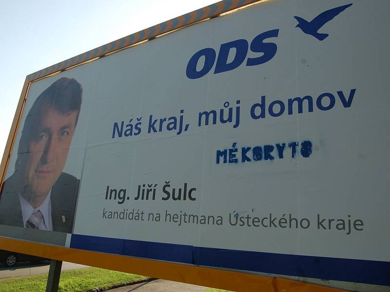 Poničený billboard ODS s posměšným textem.