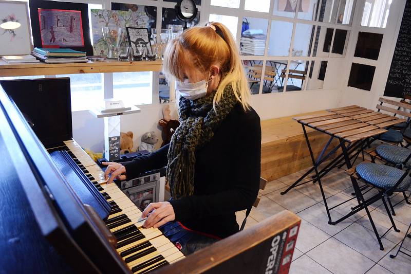 Klára Smrčková hraje na piano v opuštěné kulturní kavárně The Most café v centru Mostu.