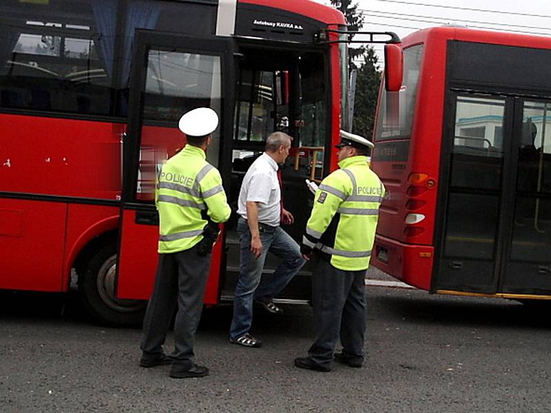 Policisté kontrolují řidiče autobusu.