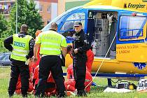 Záchranáři ošetřují zraněného chodce při páteční nehodě u mosteckého Kahanu.