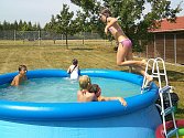 Děti dovádějí v bazénu na příměstském táboře v areálu mosteckého hipodromu, kde se učí rozumět koním.