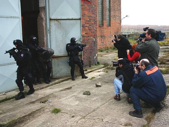 Policisté vyvádějí jednoho z teroristů. Novináře tato scéna zajímala.