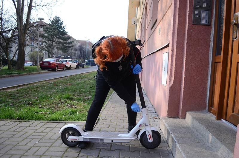 Kateřina Jermakovová rozváží v Mostě roušky na elektrokoloběžce.