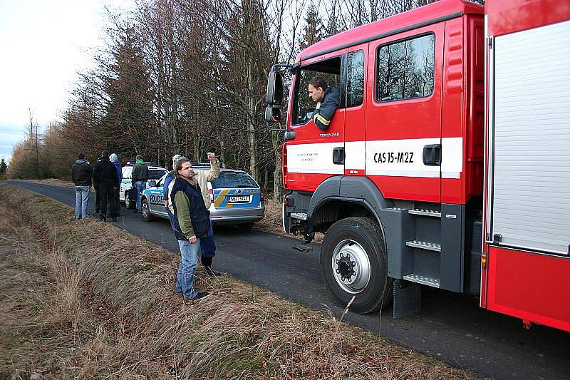 Hasiči a policisté domlouvají záchranné práce na vyproštění vrtulníku.