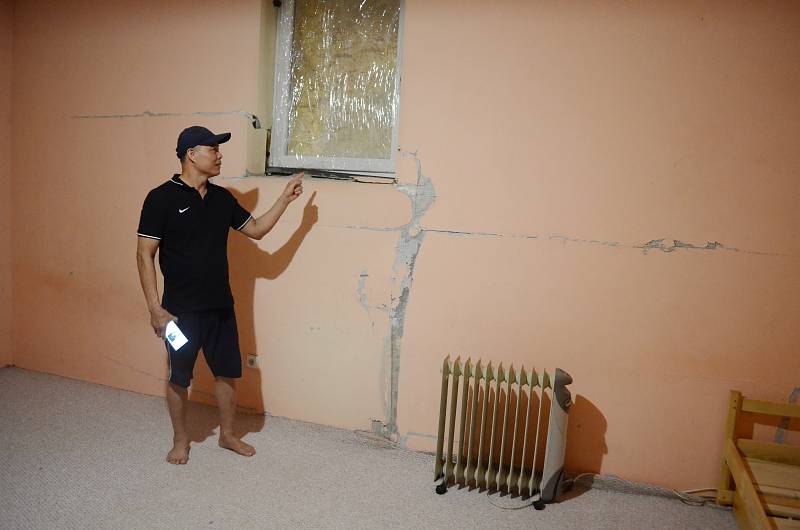 Nguyen Van Chi ukazuje poničenou stěnu a okno