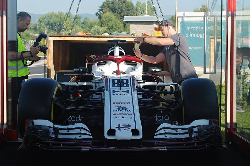 Monopost týmu Formule 1 Alfa Romeo Racing Orlen u čerpací stanice vedle litvínovské chemičky