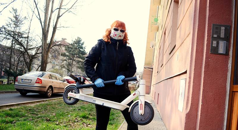 Kateřina Jermakovová rozváží v Mostě roušky na elektrokoloběžce.