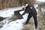 Dobrovolní hasiči a strážníci odstraňují ledové kry z potoka v Litvínově