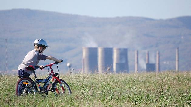 Malý cyklista si vyjel po planině u zbytkové jámy dolu Ležáky, ze kterého chce stát udělat jezero. V pozadí je Chemopetrol.