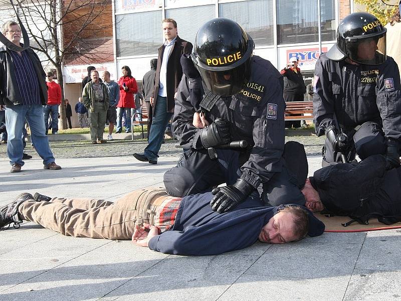 Policisté zadržují jednoho z účastníků nepovolené demonstrace.